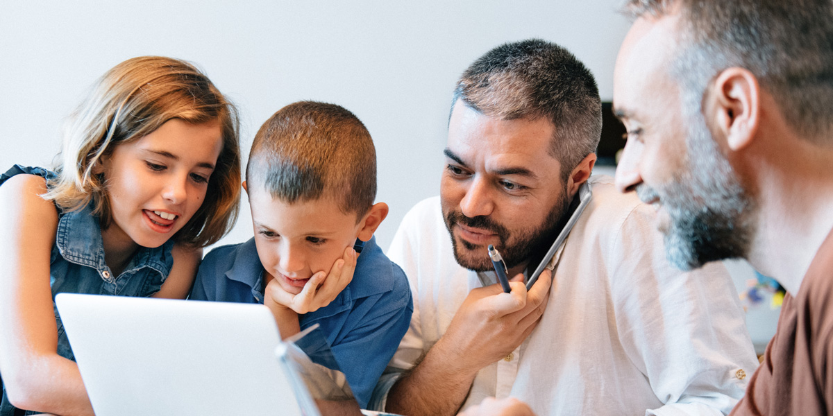 Family with two children looking at a laptop