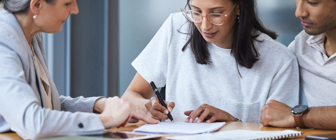 Couple signing documents with a business person