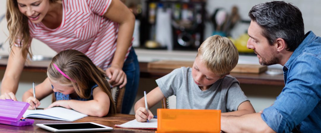 Parents helping two kids with homework