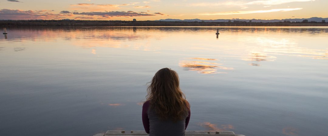 Person sitting on a boat dock