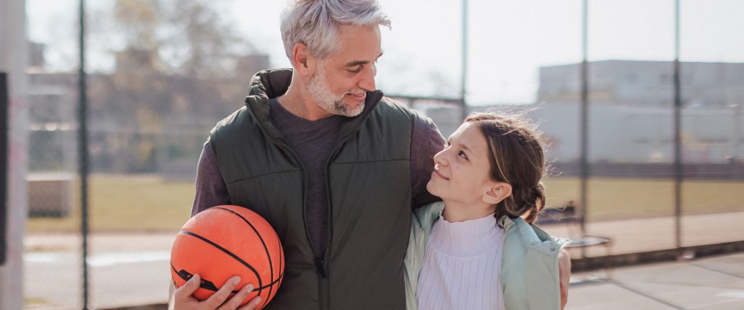 Father and daughter at a basketball court
